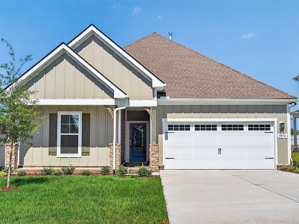 Stylish gable roof and stone accents enhance this McClure Farms home s refined suburban elegance.