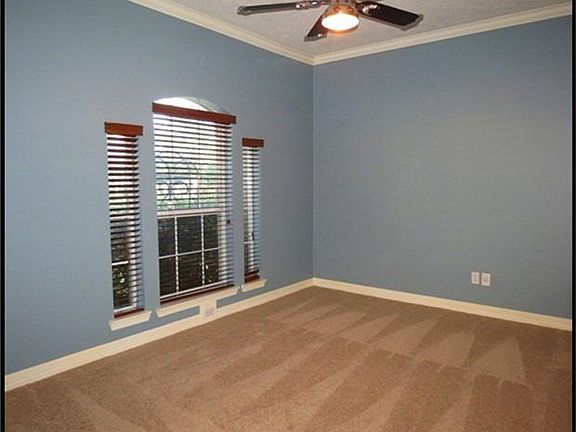 Second bedroom has custom paint, crown molding and ceiling fan.