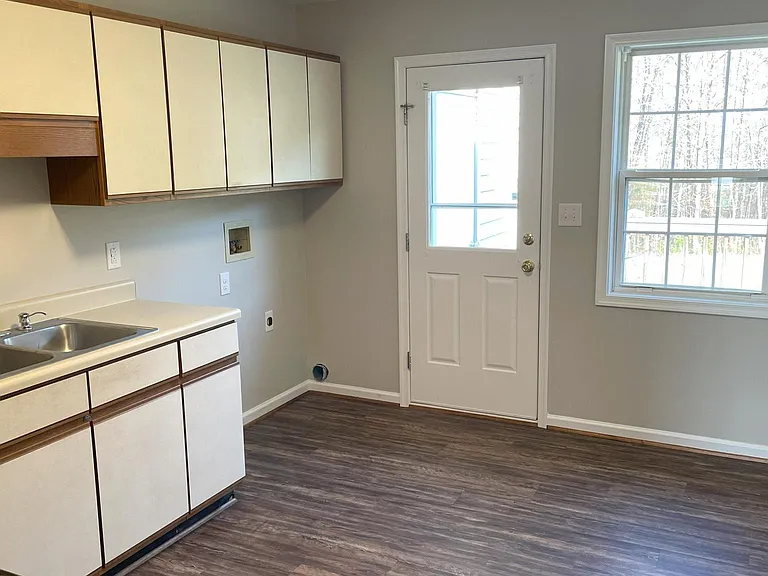 Kitchen with laundry hookups and door leading to rear deck