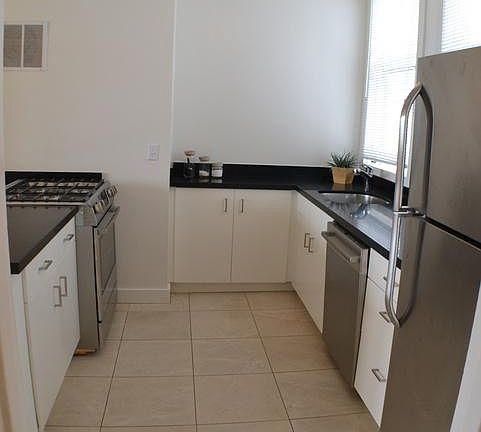 Kitchen with stainless steel appliances, large tile floor