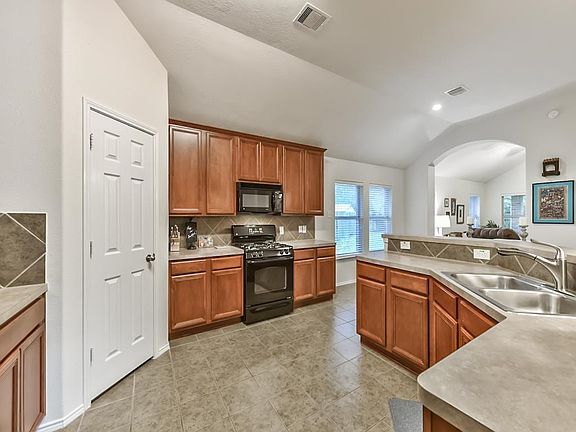 The entry leads into this spacious kitchen. High ceilings, lots of cabinets for storage and different food prep areas.
