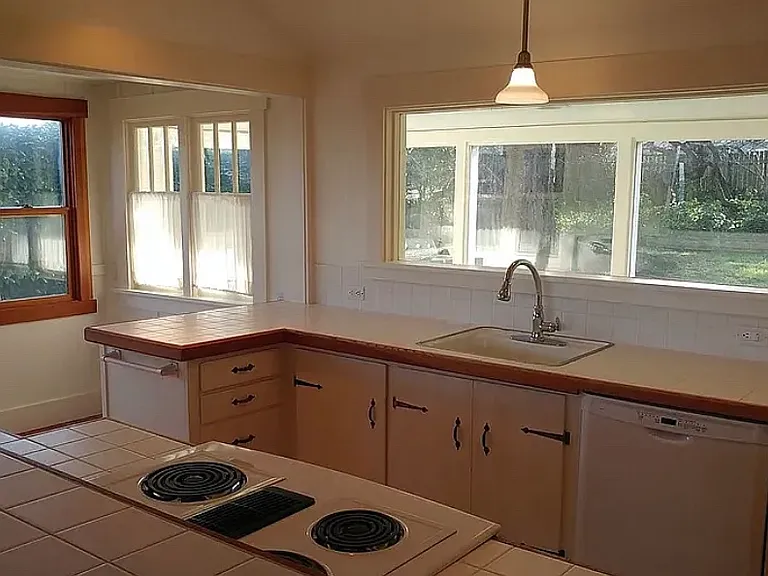 Kitchen looking into laundry room and beyond to back yard