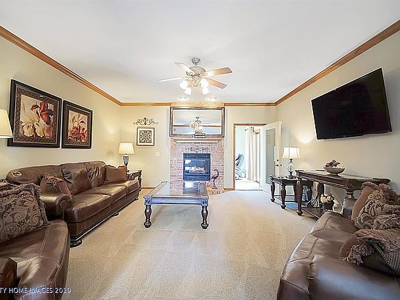Spacious living room with gas fireplace connects to the office with patio door to deck.