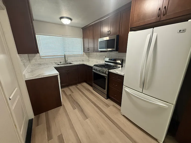 Kitchen view includes stove, microwave, refrigerator, and dishwasher.
