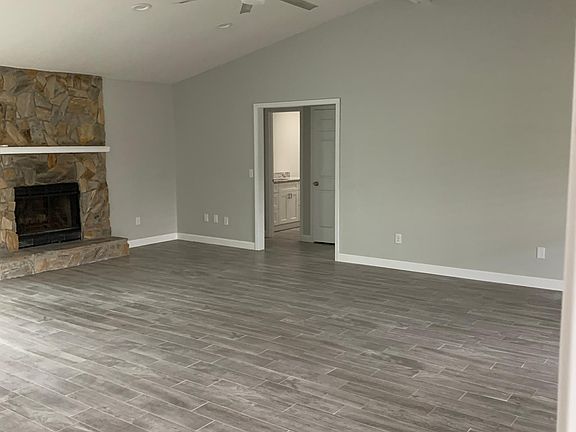 Open floor plan living room with wood-burning fireplace...Check out that awesome fan!