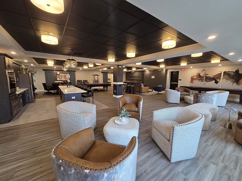 Community space at the clubhouse with a variety of seating, games, and kitchen.
