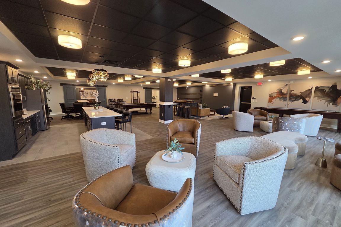 Community space at the clubhouse with a variety of seating, games, and kitchen.
