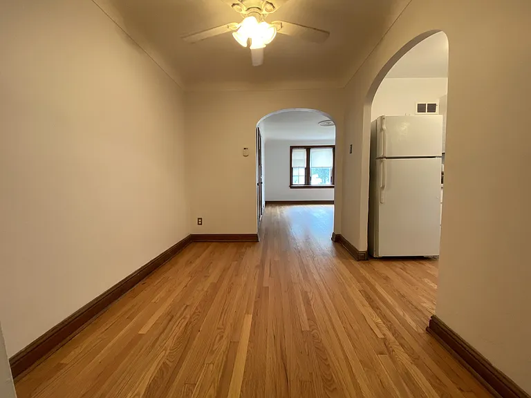 Dining room space with hardwood floors and ceiling fan.