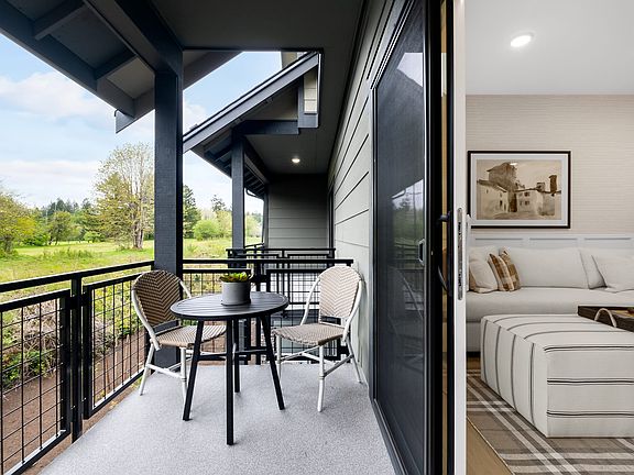 A modern, open-concept living space with a balcony overlooking a lush, green outdoor area.