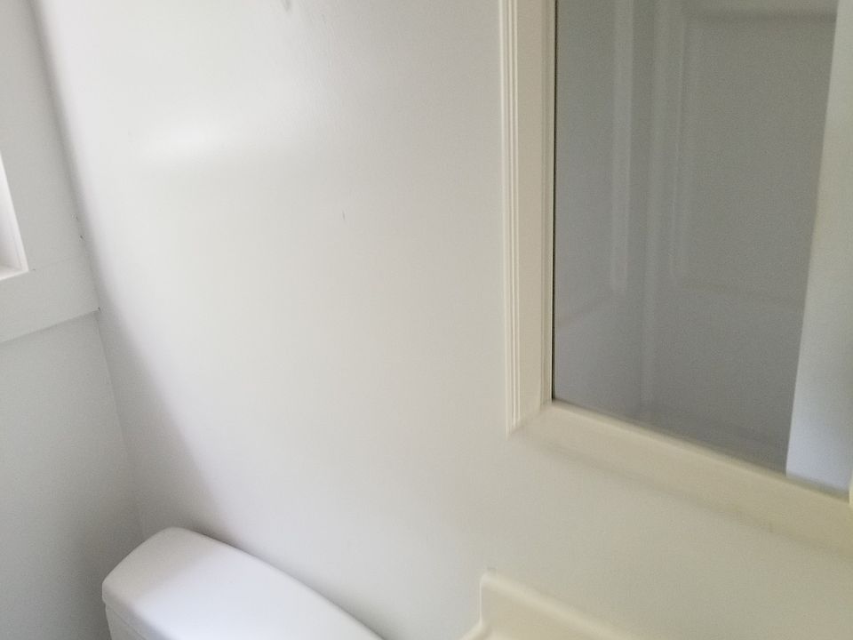 Tiny bathroom, shower visible in mirror.