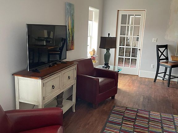 Latge great room including sectional, seating for 4 in chairs and tv/entertainment area. Game table in living area.