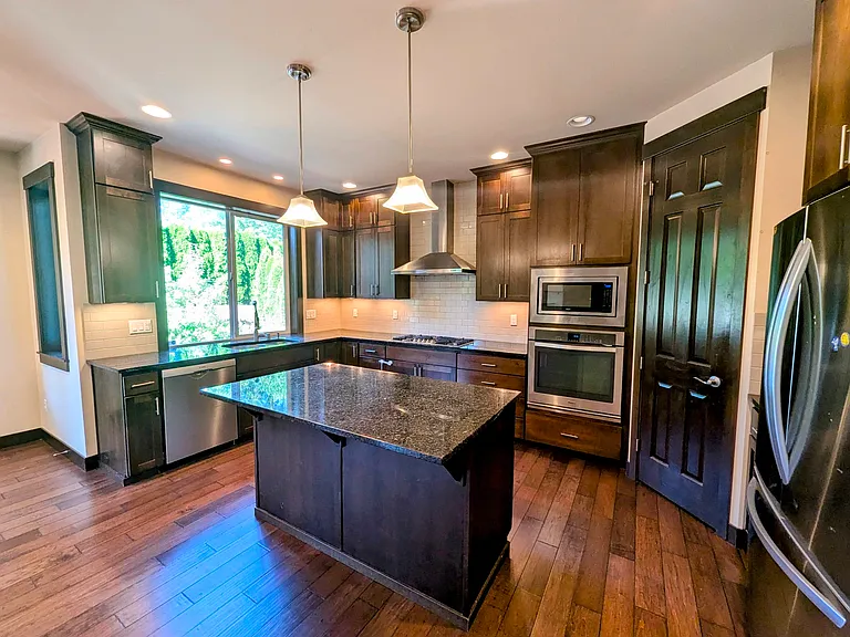 The kitchen is a culinary haven, boasting SS appliances, gas cooking, granite counters & pantry