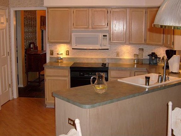 Open kitchen shares fireplace with breakfast area.