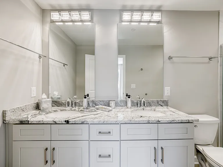The main bathroom features a spa-like double vanity and a spacious walk-in shower.