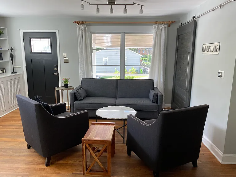 Living room area with hidden washer and dryer in closet.
