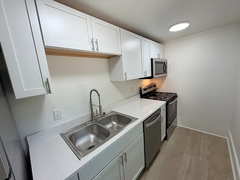 Galley kitchen with all new appliances, lighting and quartz countertops.