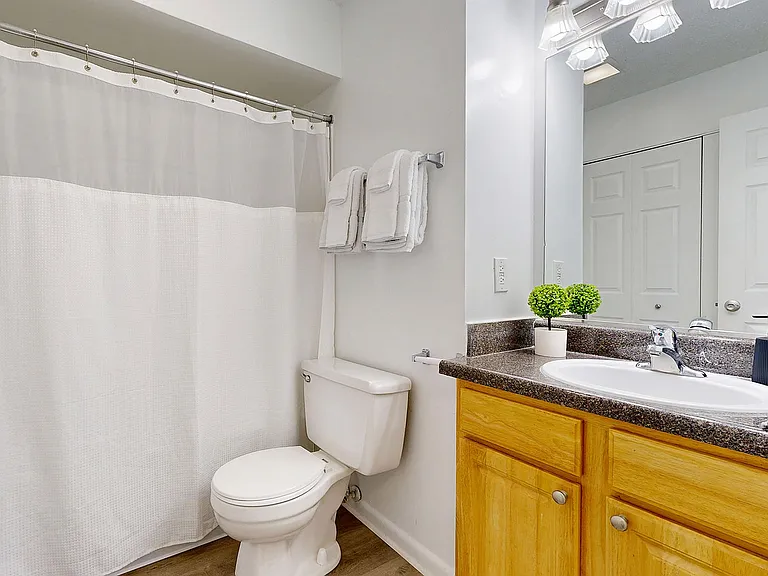 Bright bathroom with granite counters and bathtub
