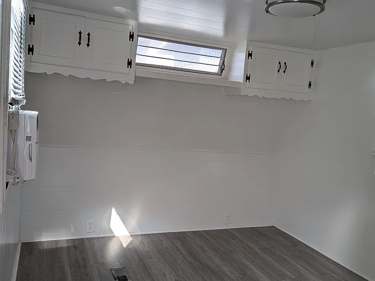 Showing the new flooring installed in living room, bedroom, and bath