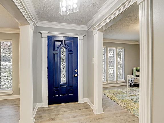 Lovely Foyer, blue front door w/decorative glass, new light fixture and new laminate wood flooring throughout first floor