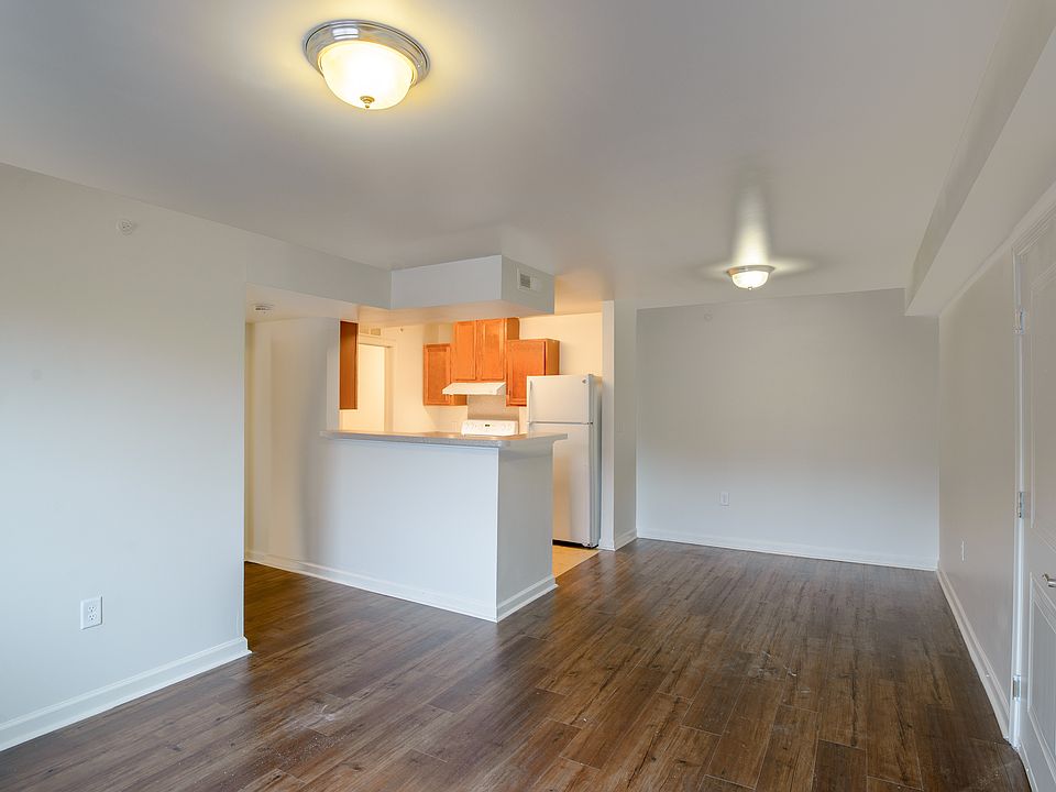 Bright and open living spaces with wood-style flooring and a breakfast bardesigned for comfort and functionality.