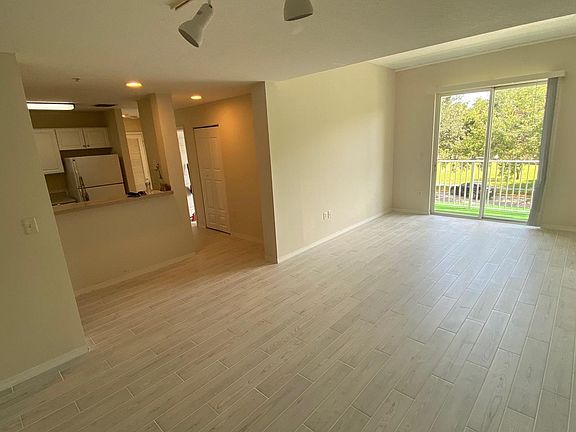 Living/Dining Area with high Ceiling and New Tile Flooring - View looking at Hallway to Bedroom 2, Bedroom 3 and 2nd bathroom