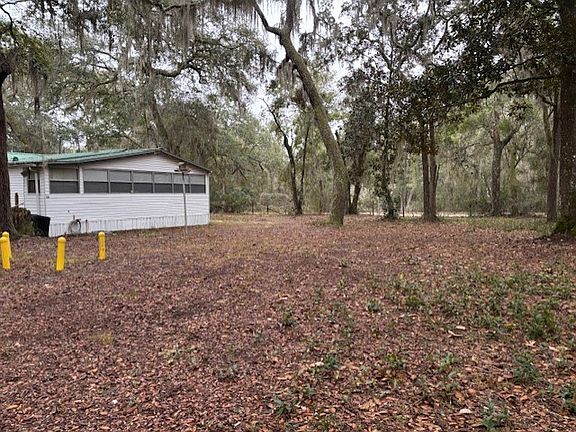 Side yard has plenty of room and beautiful trees.