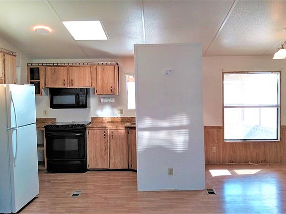 Refrigerator, new microwave, matching stove/oven, LED lighting, Skylights, Dining room to right has view of back yard