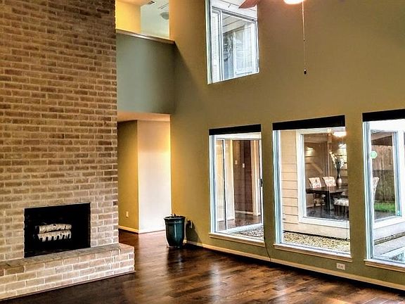 DRAMATIC VAULTED CEILINGS LOOKING UP TO UPSTAIRS BALCONY AND THROUGH TO DINING ROOM FROM LIVING ROOM!