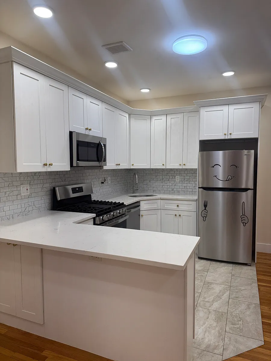 Fully renovated kitchen with white shaker cabinets, quartz countertops, and stainless steel appliances including a dishwasher. - Middletown Rd