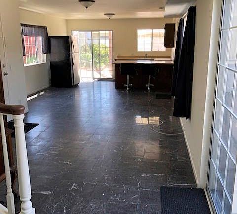 Guesthouse living room and kitchen with eating area and two refrigerators.