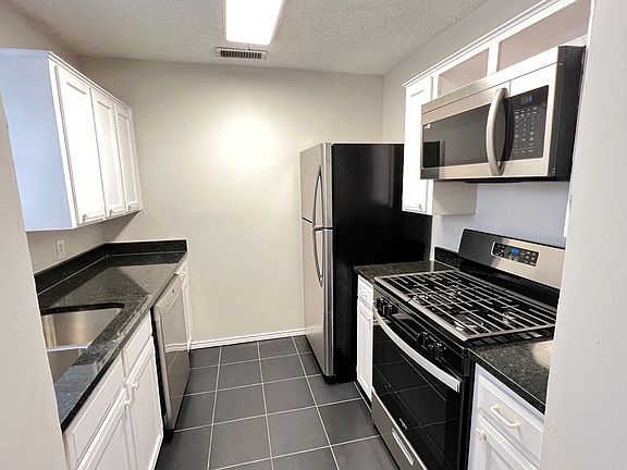 Modern kitchen with new appliances and tile flooring