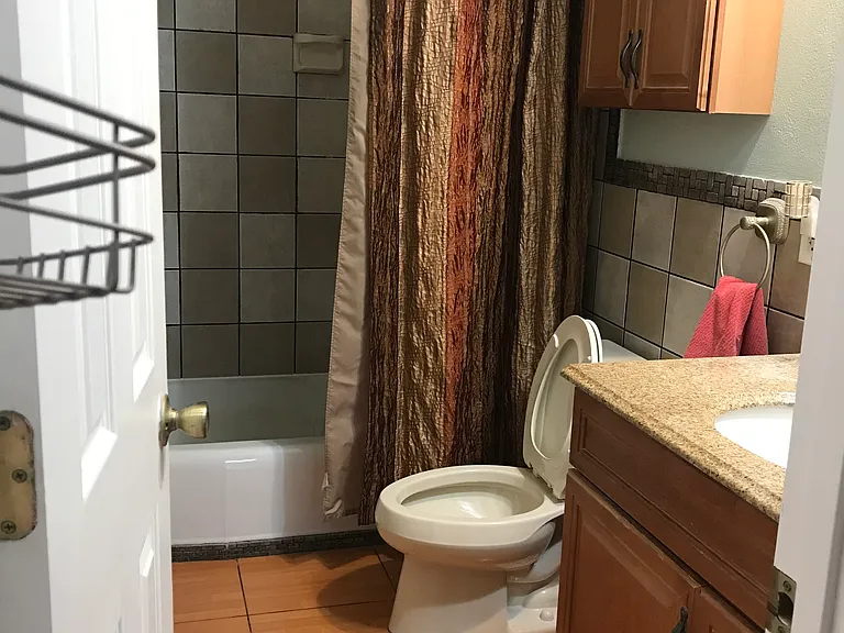 Private bathroom w bathtub off the hallway.