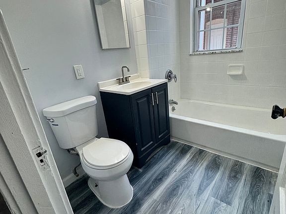Full bathroom with tub and vanity storage