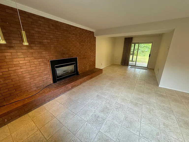 Lower level den with fireplace and basement walkout to back yard.