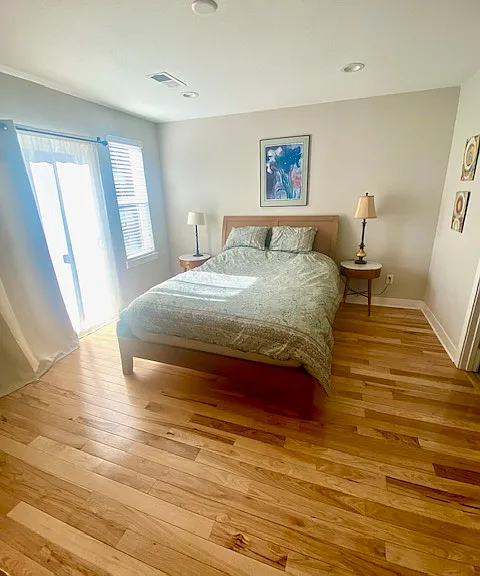 Primary bedroom with balcony and attached bathroom