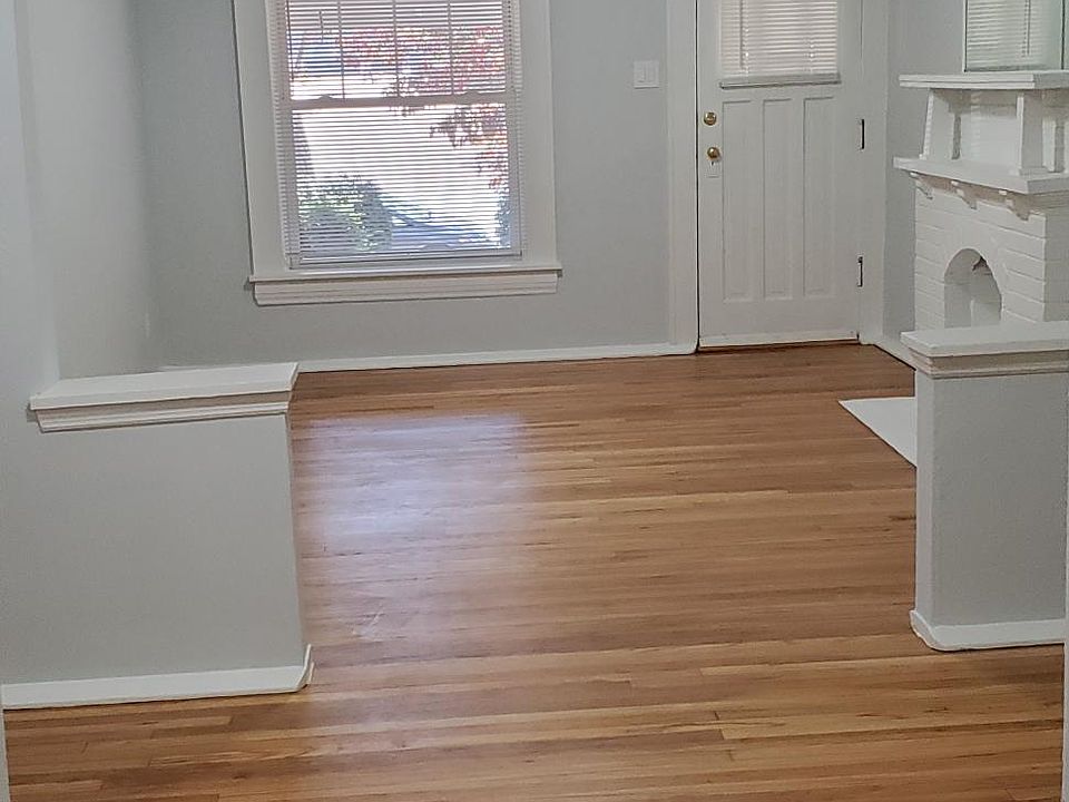 View of the front 2 rooms looking toward the front door. Gorgeous just refurbished hardwood. New ceiling fans.