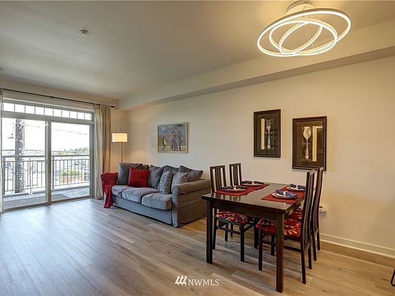 Dining room and living room make up the great room concept (kitchen to the right) Private patio, electric fireplace and updated light fixtures make up this space.