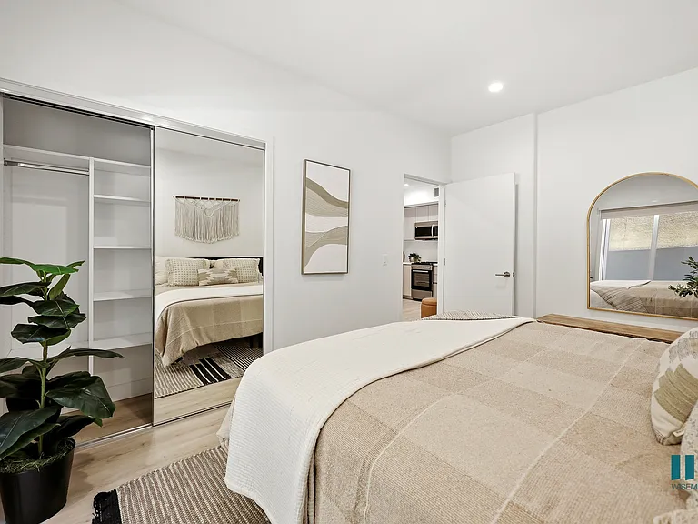 Bedroom with a Mirrored Closet and Built-In Shelving