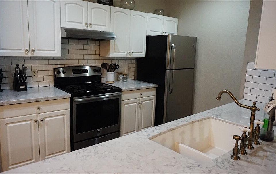 Updated kitchen. Quartz countertops, stainless appliances, subway tile backsplash. Deep sink with garbage disposal and brass fixture. Refrigerator includes an ice maker in the freezer. Not pictured: pantry and pullout trash.