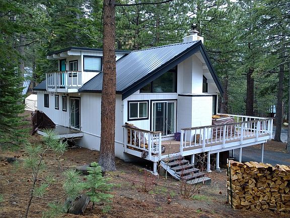 side view with (L to R) back kitchen deck, upstairs bedroom/office deck, wrap-around front deck and living room slider