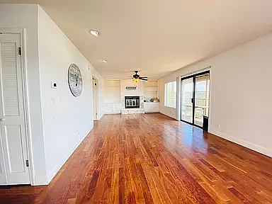 Living rm w/ fireplace & bookshelves.