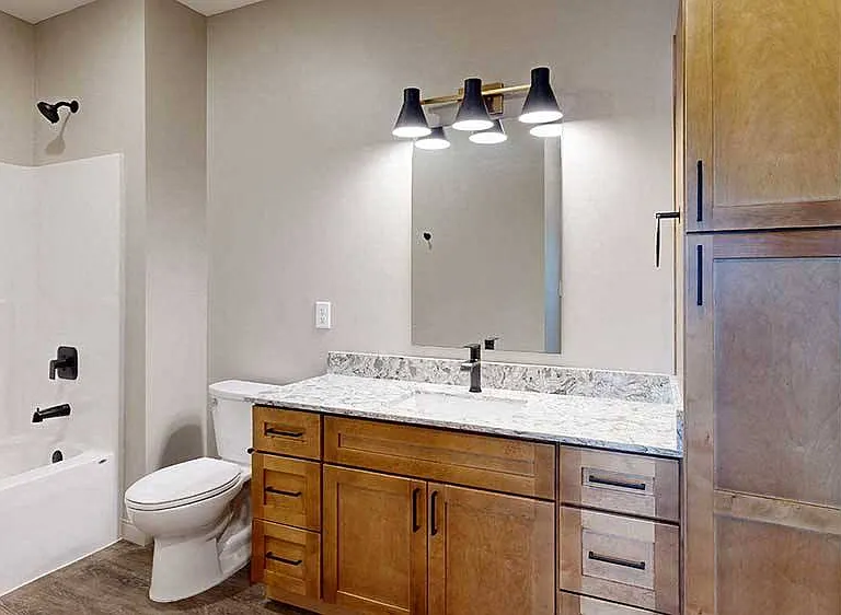 A stylish and functional bathroom featuring a sleek quartz vanity, elegant lighting, and high-end finishes.