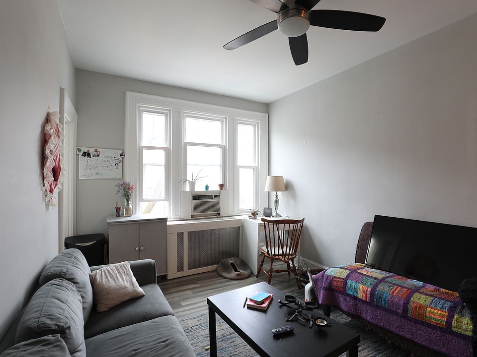 Bright living room with large windows and ceiling fan