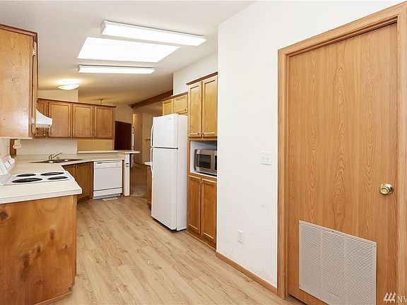 New laminate flooring in kitchen and kitchen eating area. Door leads to large utility room. 