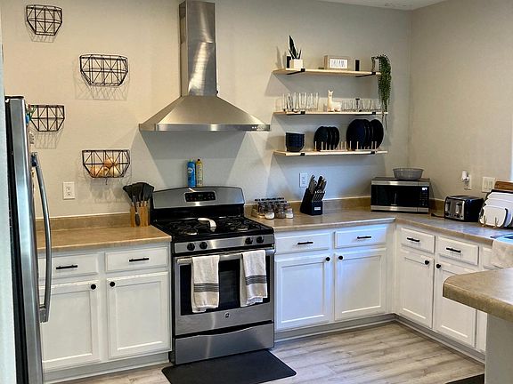Kitchen w/open shelving and stainless steel appliances