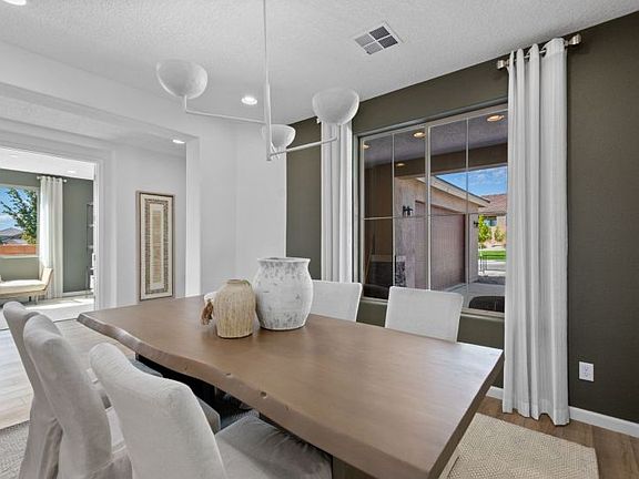 Formal dining room with an accent wall and beautiful modern chandelier.