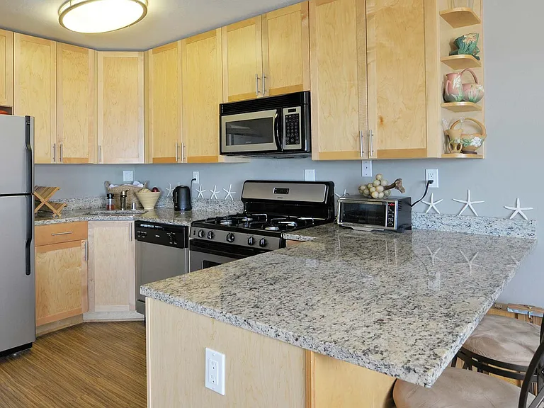 Kitchen includes stainless steel appliances and granite countertops