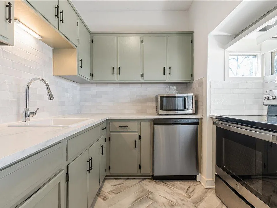 Freshly updated kitchen includes refinished cabinets, newer flooring, appliances, countertops and backsplash. Oven nook looks out to the front of property.