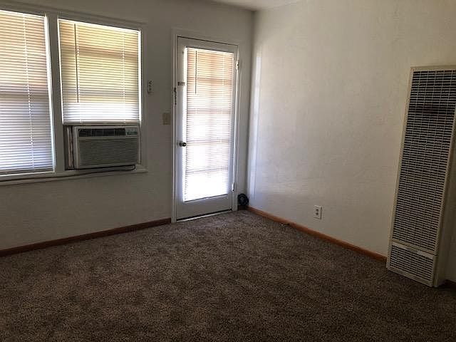 Living room with new carpet, window A/C and wall heater
