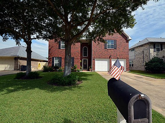 A view of the entire front yard. Home has a basketball hoop installed in the driveway, at home mail 